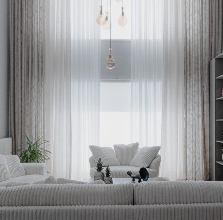 Ruang tamu minimalis modern dengan furnitur sederhana dan pencahayaan alami di rumah tinggal Yogyakarta