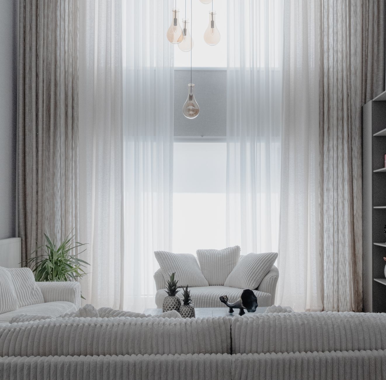 Ruang tamu minimalis modern dengan furnitur sederhana dan pencahayaan alami di rumah tinggal Yogyakarta
